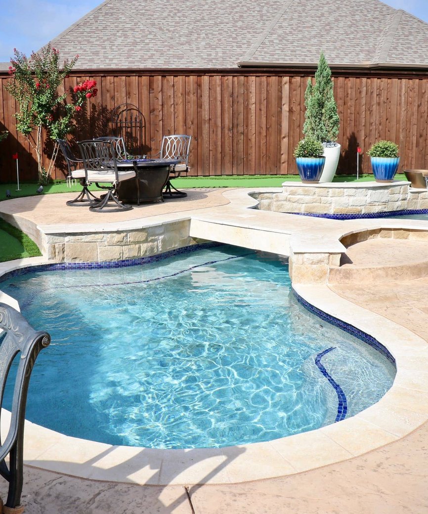 Custom freeform pool with natural stone decking and integrated landscaping